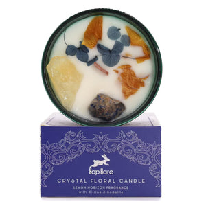 The Sun tarot-inspired crystal candle featuring raw Citrine and Sodalite gemstones — Botanical ritual candle for success, abundance, and joy, decorated with dried flowers.